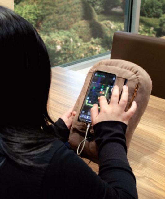 woman brown potato pillow phone older phone stand PhoneSpud phone accessory holds smartphone cell phone while resting in bed gaming watching videos scrolling bedtime phone use helps hand strain carpal tunnel arthritis