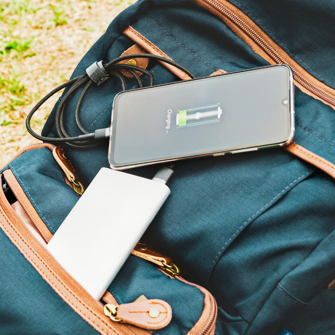 image of a phone plugged into a power bank. The screen of the phone displays a message that the phone is charging.