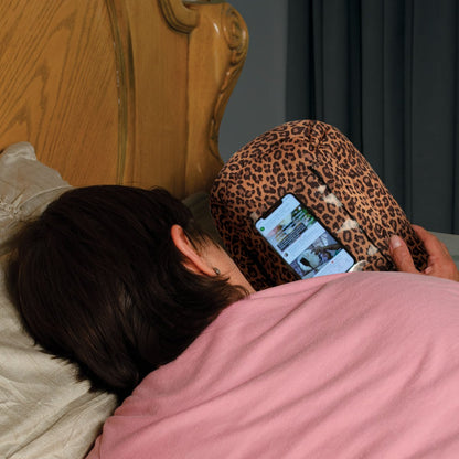woman resting using leopard print potato pillow phone holder phone stand PhoneSpud phone accessory holds smartphone cell phone while resting in bed gaming watching videos scrolling bedtime phone use helps hand strain carpal tunnel arthritis using your phone in bed bedtime for kids elderly patients women