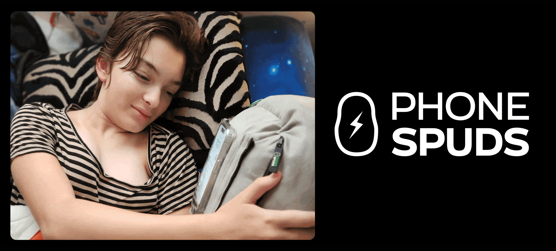 smiling child laying in bed using a gray phonespud the lightning bolt portion of the phonespud flickers