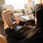 Woman uses brown potato pillow phone stand phone accessory for holding smartphone cell phone for gaming scrolling watching videos