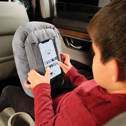 Child using cell phone smartphone in gray pillow phone stand while traveling in the car, phone pillow for kids