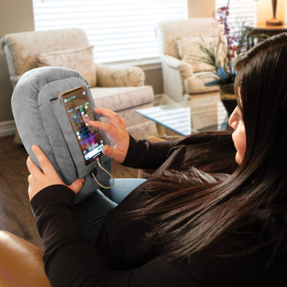 Woman uses pillow phone stand PhoneSpud to hold smartphone cell phone while playing games on their phone phone accessories